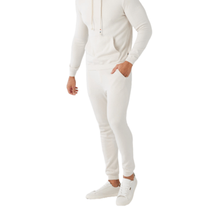 A person is wearing a white hoodie, white jogger pants, and white sneakers.