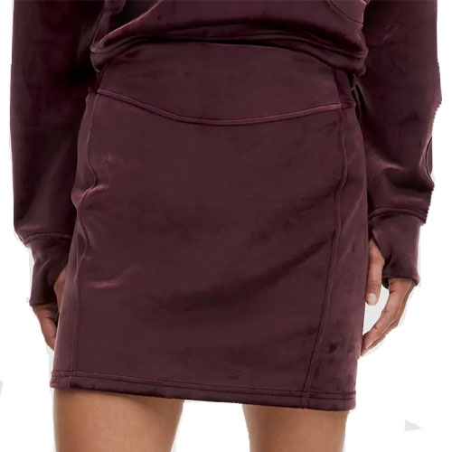 A maroon velvet mini skirt paired with a matching long-sleeve top.