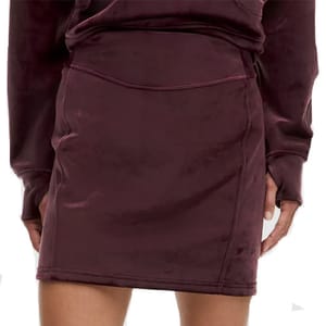 A maroon velvet mini skirt paired with a matching long-sleeve top.