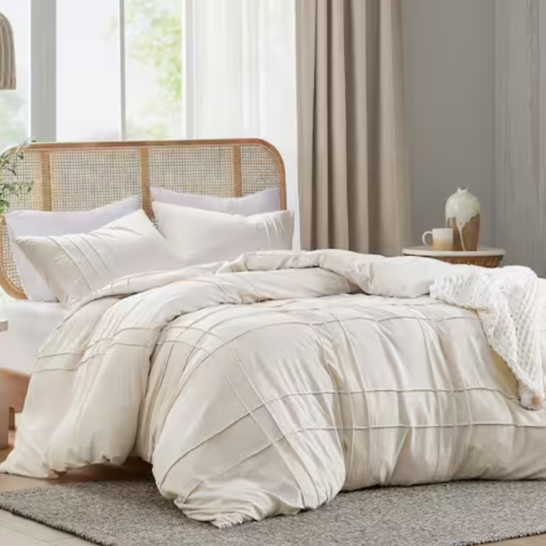 A king-sized duvet cover set featuring a neutral striped pattern with two matching pillow shams, displayed on a bed with a rattan headboard.