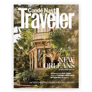 Magazine cover of Condé Nast Traveler featuring a historic building in New Orleans, highlighting travel destinations such as Lake Como, Yunnan Province, and Byron Bay, and discussing wellness vacations.