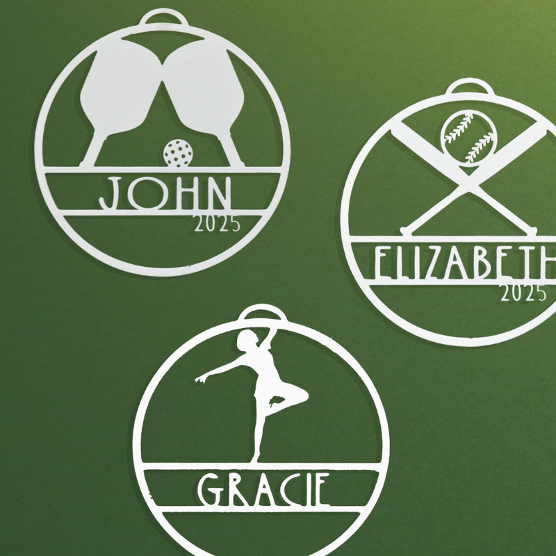 Three personalized sports-themed ornaments feature a pickleball set for John, a baseball design for Elizabeth, and a gymnast pose for Gracie, all marked with \“2025.\“