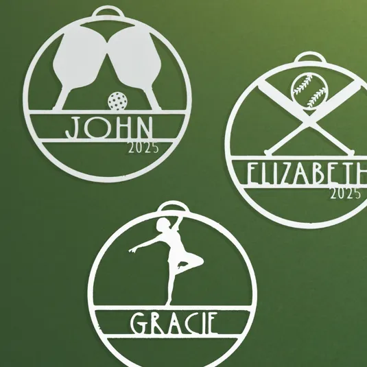 Three personalized sports-themed ornaments feature a pickleball set for John, a baseball design for Elizabeth, and a gymnast pose for Gracie, all marked with \“2025.\“