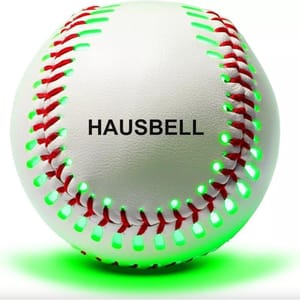The image shows a HAUSBELL light-up baseball with red stitching and green glowing lights around the seams.