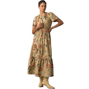 A beige, floral-patterned maxi dress with short puff sleeves and a tiered skirt, paired with light tan boots.