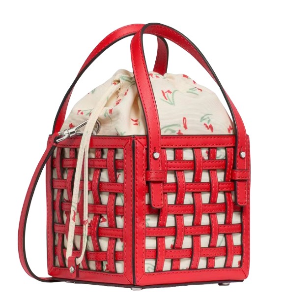 A red woven leather bucket bag with a short handle and crossbody strap, featuring a drawstring canvas pouch inside with a floral print.