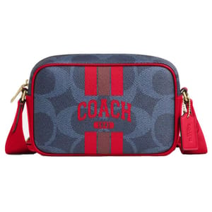A Coach shoulder bag featuring a blue and red design with the brand's logo and stripes on the front, along with red accents and a detachable tag.