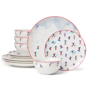 A set of dinnerware featuring plates and bowls with a colorful skier and snowboarder pattern, outlined in red.