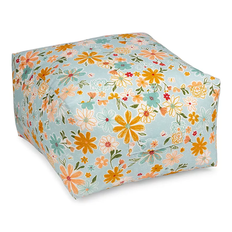 A floral-patterned bean bag or floor cushion with a square shape, featuring yellow, orange, pink, and blue flowers on a light blue background.