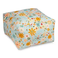 A floral-patterned bean bag or floor cushion with a square shape, featuring yellow, orange, pink, and blue flowers on a light blue background.