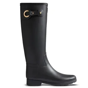 A tall black rubber rain boot features a decorative gold buckle and strap detail near the top.