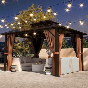 A gazebo with curtains, string lights, an outdoor corner sofa, and decorative side tables.