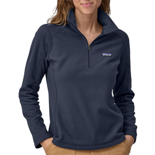 A woman wearing a blue Patagonia quarter-zip fleece pullover with a logo on the chest and tan pants.