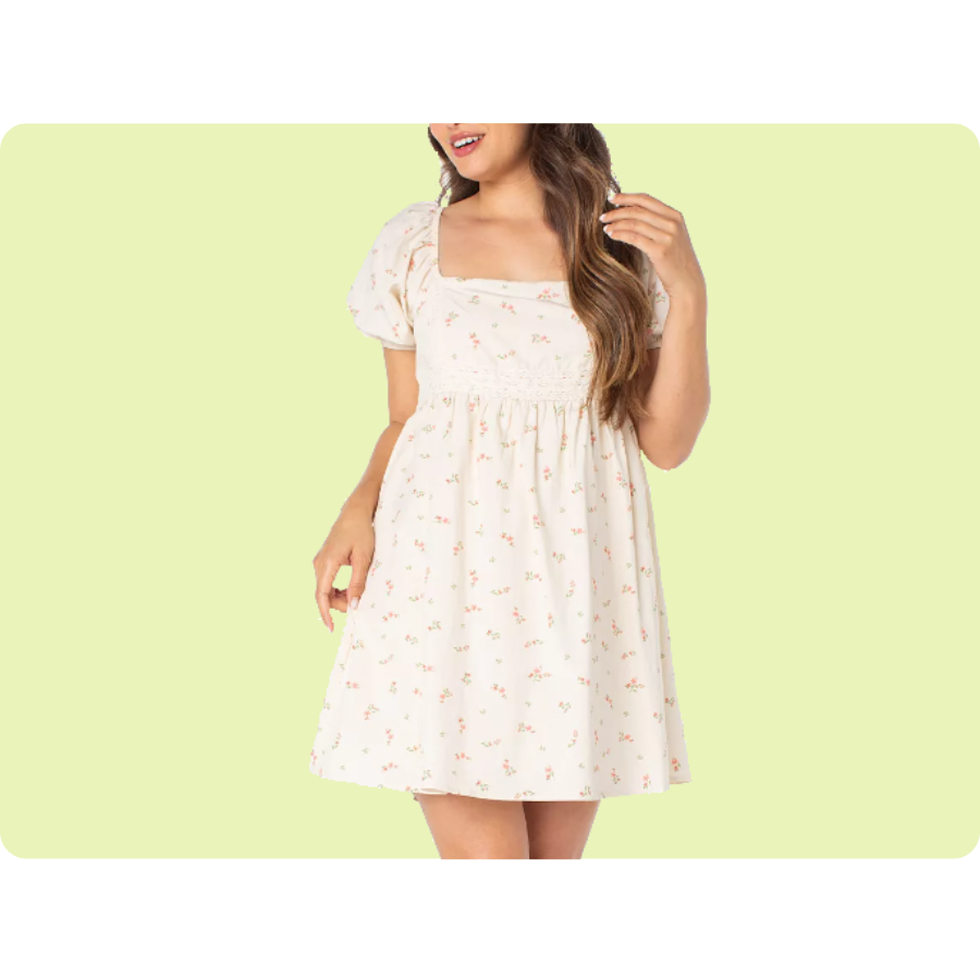 A woman is wearing a short, cream-colored dress with puff sleeves and a subtle floral pattern.