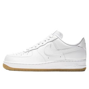 White Nike Air Force 1 '07 sneakers feature a low-top design with a white leather upper, perforated toe box, and a gum rubber outsole. The side showcases the iconic Nike swoosh.