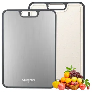 Dual-sided cutting board with a stainless steel side and a textured non-slip side, trimmed in gray, accompanied by a basket of fruits and vegetables.