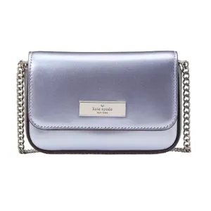 A metallic silver Kate Spade New York crossbody bag with a chain strap and logo plaque on the front.