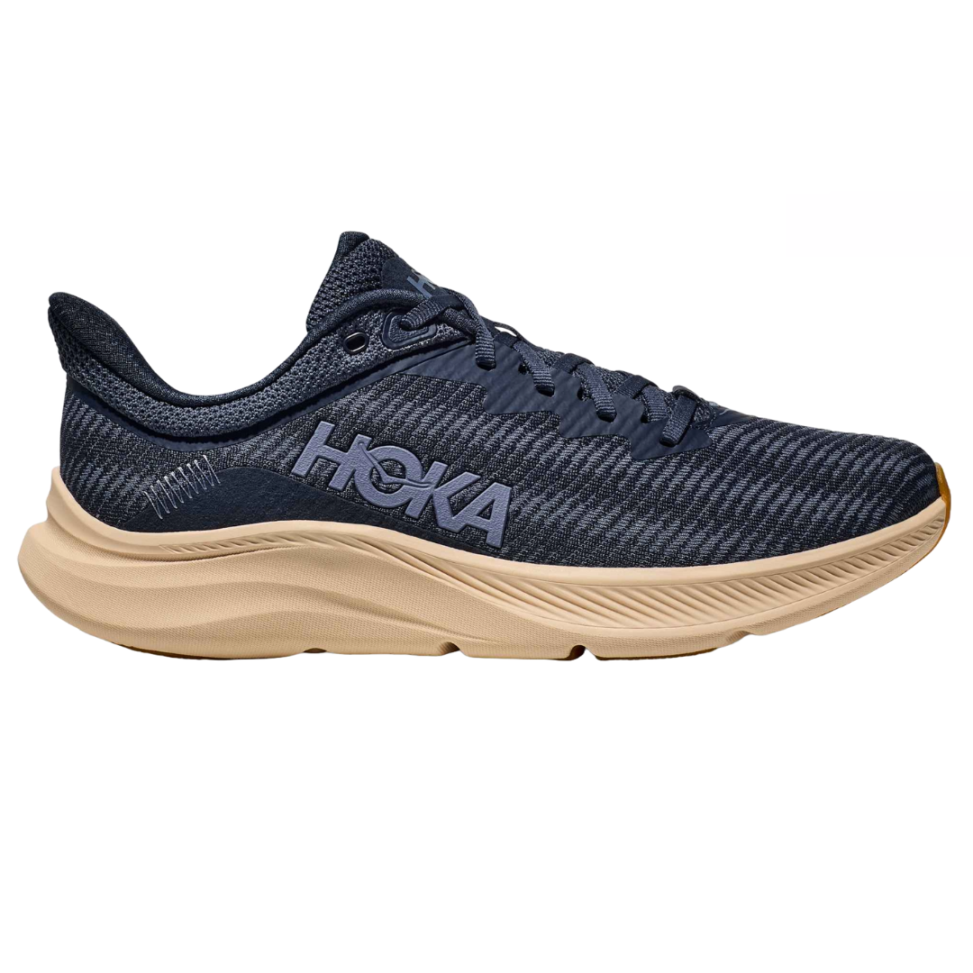 Hoka Men's Solimar Shoes feature a sleek design with a navy upper and beige sole, showcasing the brand's logo on the side. They offer lightweight support and cushioning, ideal for running or casual wear.