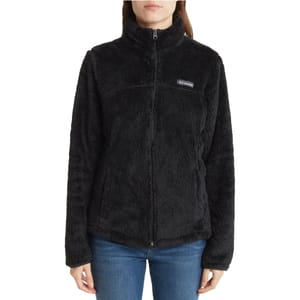 A woman is wearing a black fleece jacket with a high collar and zip front, branded with the Columbia logo on the left chest.