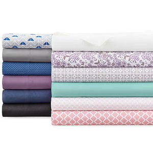 A stack of folded bed sheets featuring various colors and patterns, including geometric designs, floral prints, and solid colors.