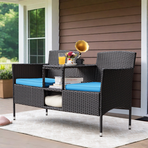 A wicker loveseat with blue cushions and a center table, set on a beige outdoor rug.