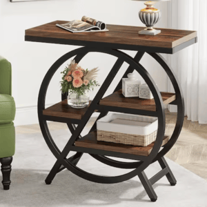 A modern end table featuring a wooden top and three-tier shelving with circular metal frame design, holding a lamp, a vase with flowers, decorative boxes, and a wicker basket.