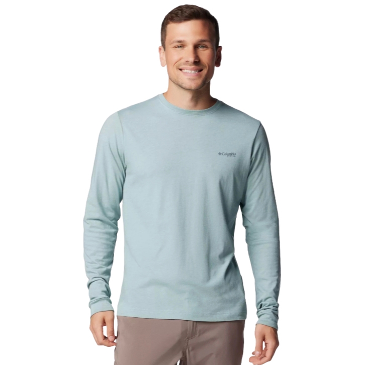 A man is wearing a light blue long-sleeve Columbia shirt with brown pants.