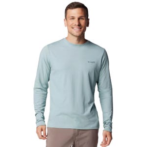 A man is wearing a light blue long-sleeve Columbia shirt with brown pants.