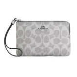 A Coach wristlet with a zip closure featuring the brand's signature 'C' pattern and a detachable strap.