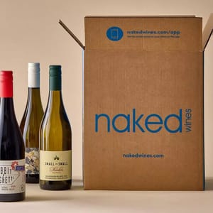Three wine bottles are displayed next to a cardboard box labeled \“naked wines,\“ indicating a wine delivery service.