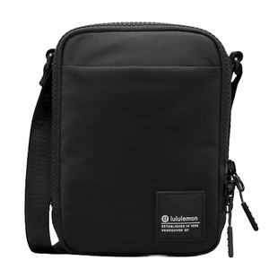 A black Lululemon shoulder bag with a front zipper compartment and an adjustable strap; the label indicates establishment in 1998, Vancouver, BC.