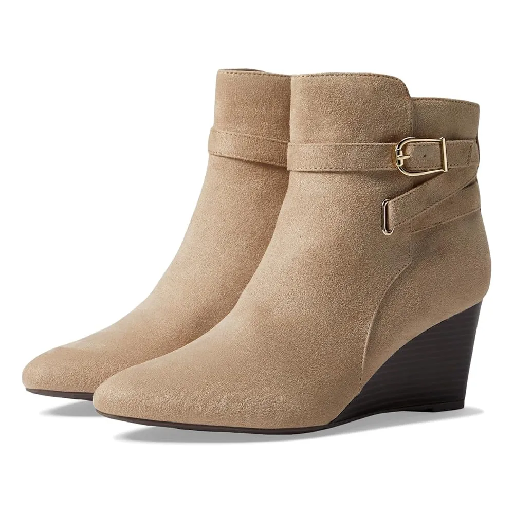 Beige suede ankle boots with wedge heels and decorative ankle straps featuring gold buckles.