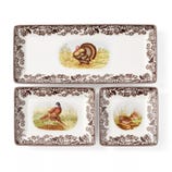 A set of three rectangular plates with floral borders and wildlife illustrations, featuring a turkey, pheasants, and a quail.