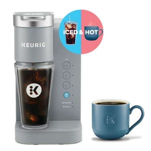 Keurig coffee maker capable of brewing both iced and hot beverages, accompanied by a cup of iced coffee and a mug of hot coffee.