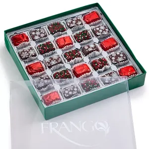 A 25-piece box of Frango Holiday Milk Mint Chocolates in a green box, featuring chocolates wrapped in red foil and topped with festive sprinkles and snowflake decorations.