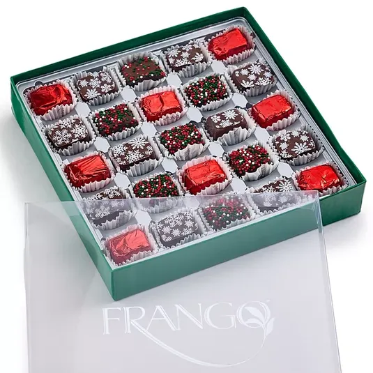A 25-piece box of Frango Holiday Milk Mint Chocolates in a green box, featuring chocolates wrapped in red foil and topped with festive sprinkles and snowflake decorations.
