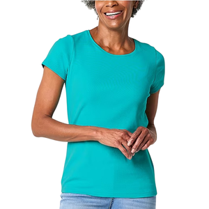 A woman is wearing a pink short-sleeve tee with a round neckline and a relaxed fit. She pairs it with beige pants.