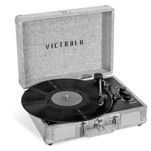 Victrola vintage suitcase-style turntable in a textured gray finish with a classic black vinyl record playing and prominent Bluetooth speaker controls.