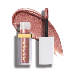 A Stila liquid eyeshadow with a metallic rose-gold shade, shown with an open applicator and a swatch of the color.