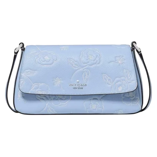A light blue leather shoulder bag with a floral embossed pattern and a flap closure, featuring a thin strap and the Kate Spade New York logo on the front.
