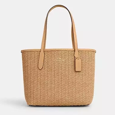 A beige woven tote bag with tan leather handles.