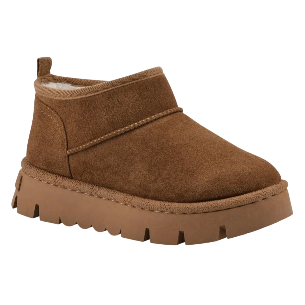 A brown suede ankle boot with a thick rubber sole and a pull tab at the back, featuring a cozy shearling interior lining.
