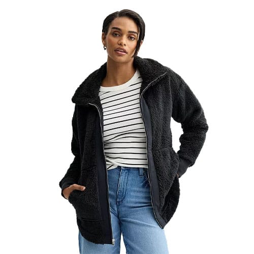 Sonoma Cozy Full-Zip Jacket features a full zip closure, a plush black fabric, front pockets, and a high collar. It is styled with a casual striped shirt and medium-wash jeans.