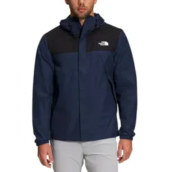 A man wearing a navy and black North Face jacket with a hood and elastic cuffs.