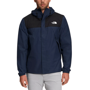 A man wearing a navy and black North Face jacket with a hood and elastic cuffs.