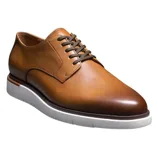 A tan leather derby shoe with dark brown laces and a white rubber sole.