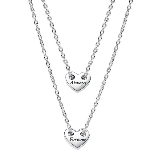 Two silver necklaces with heart-shaped pendants, one inscribed with \“Always\“ and the other with \“Forever\“. Each pendant is suspended from a delicate chain.