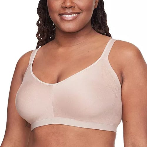 A woman wearing a beige, wireless bra with thin straps, designed for comfort and support.