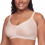 A woman wearing a beige, wireless bra with thin straps, designed for comfort and support.