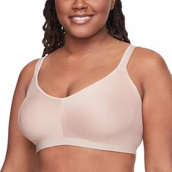 A woman wearing a beige, wireless bra with thin straps, designed for comfort and support.
